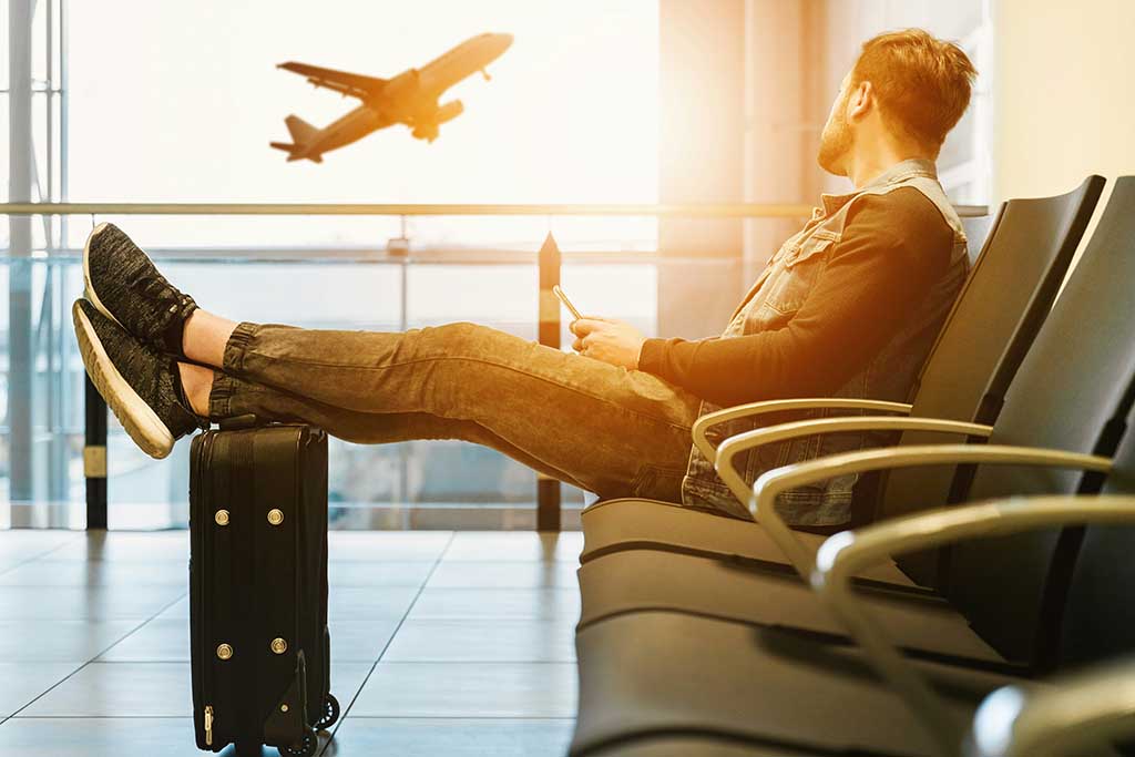 Person som har åkt flygbuss till flygplatsen och nu sitter och väntar på sitt flyg